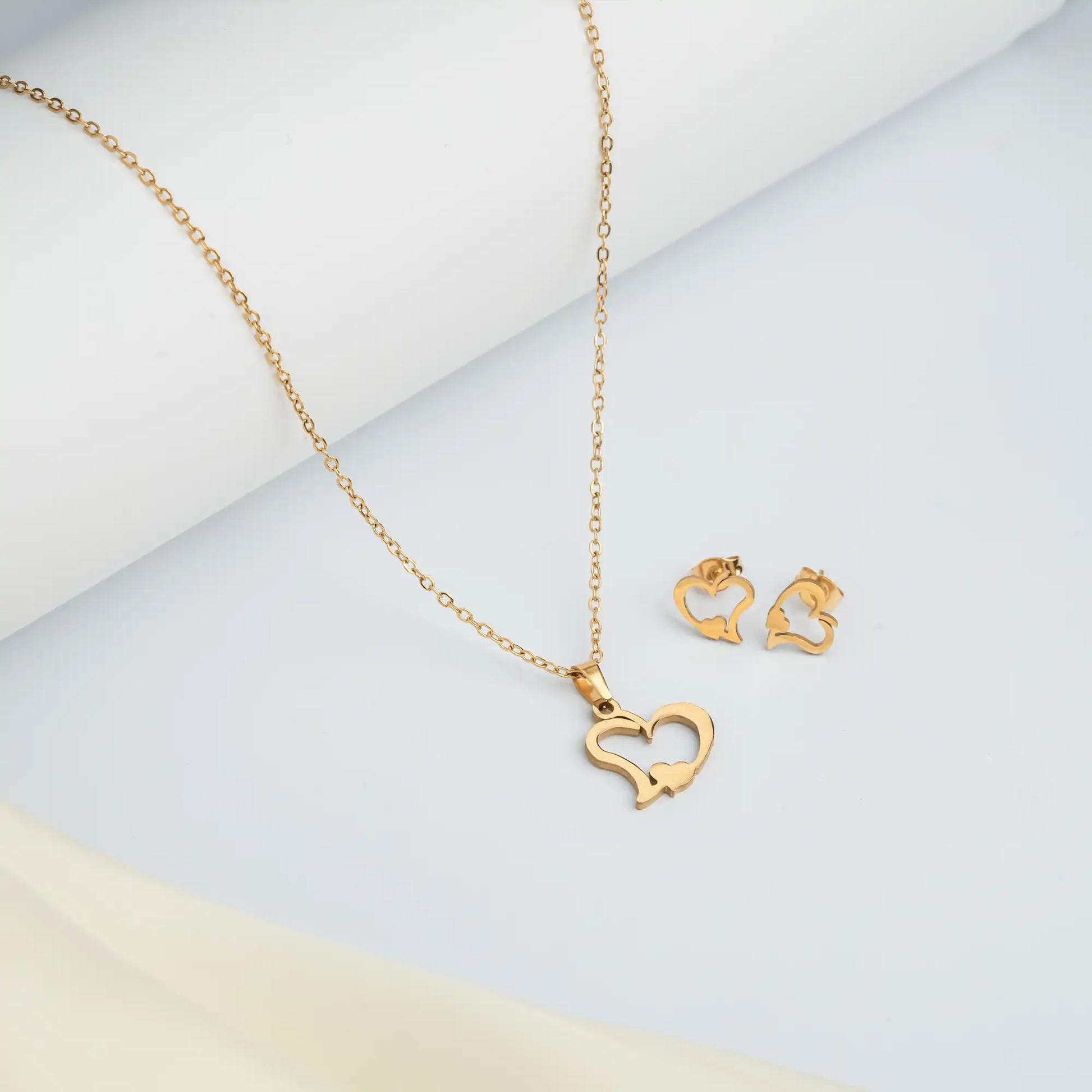 Tan. gold heart necklace and earring gift set with premium branded packaging.