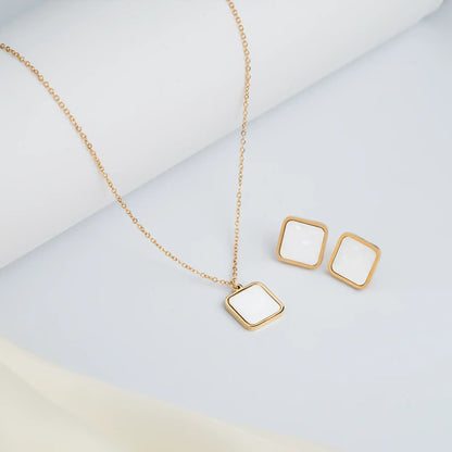 gold chain and white square pendant set with studs