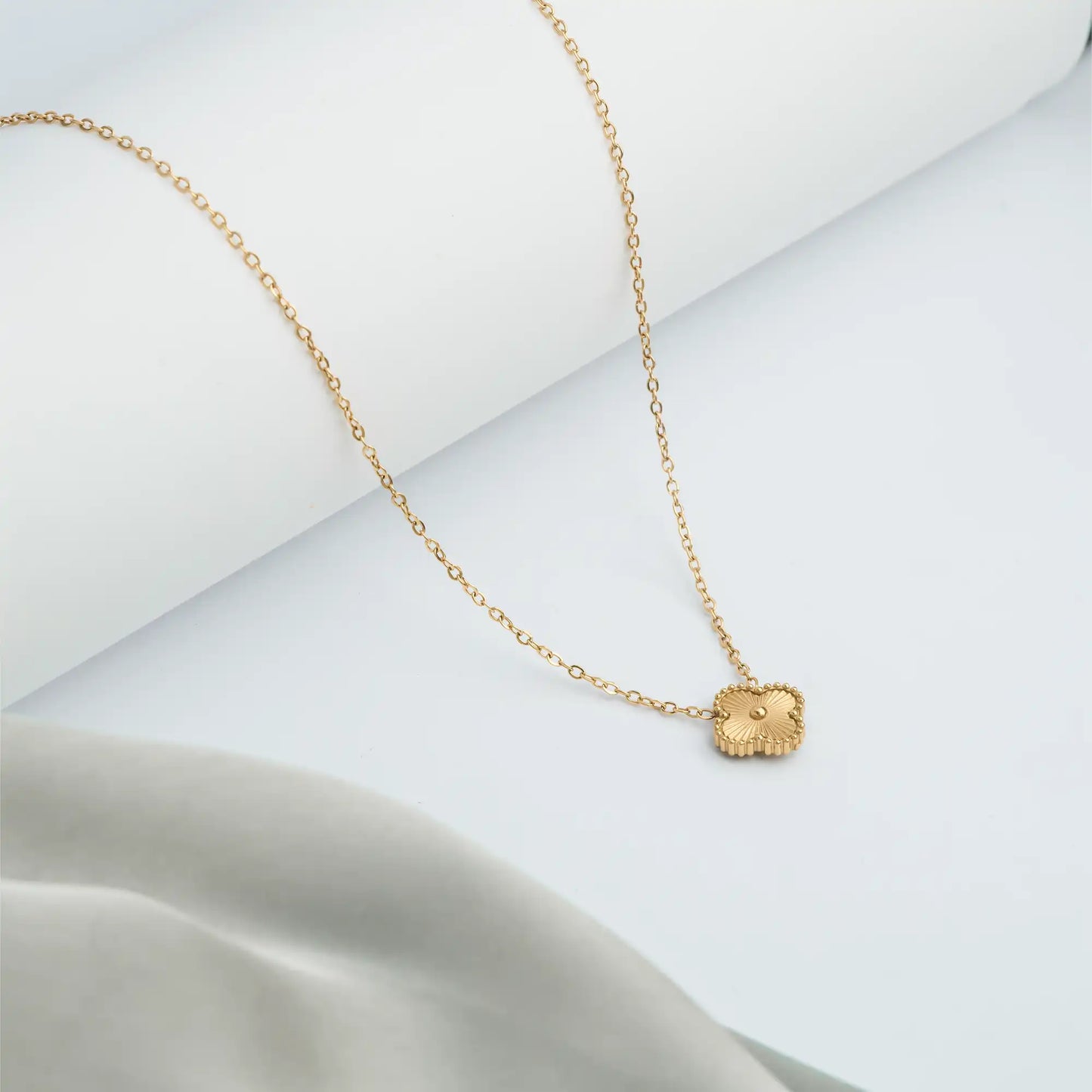 gold necklace with a small clover pendant