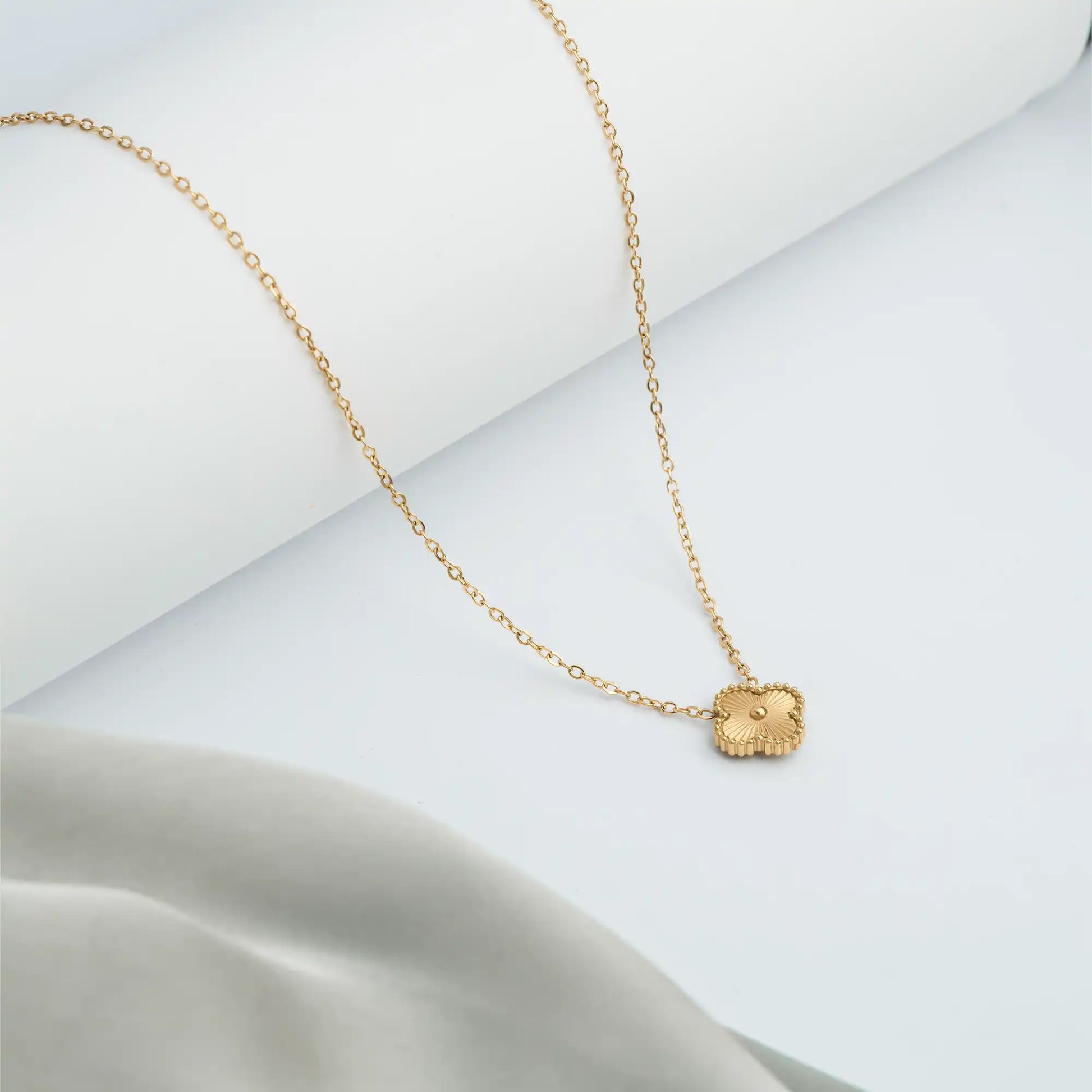 gold necklace with a small clover pendant