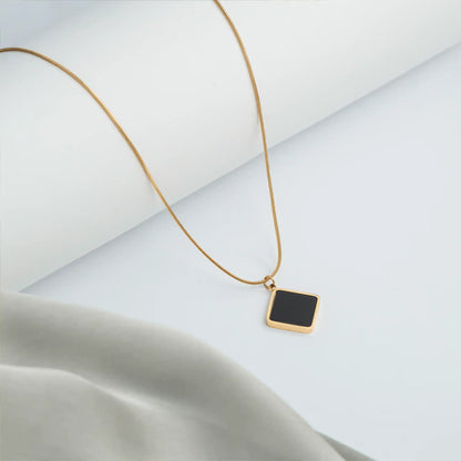 gold necklace with black pendant and delicate chain
