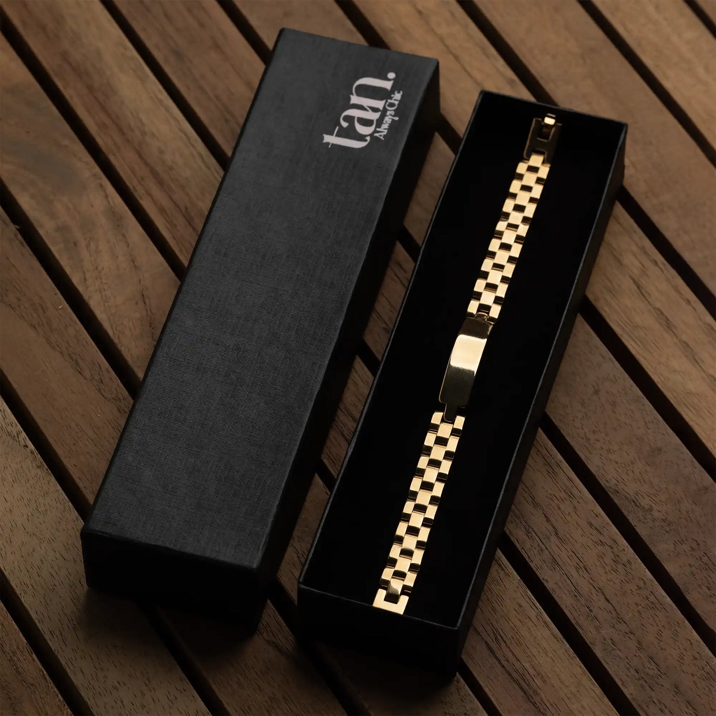 Men's golden stainless steel link bracelet with polished ID bar by tan.