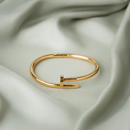 Gold nail bangle bracelet  for women with a polished finish and hinged clasp