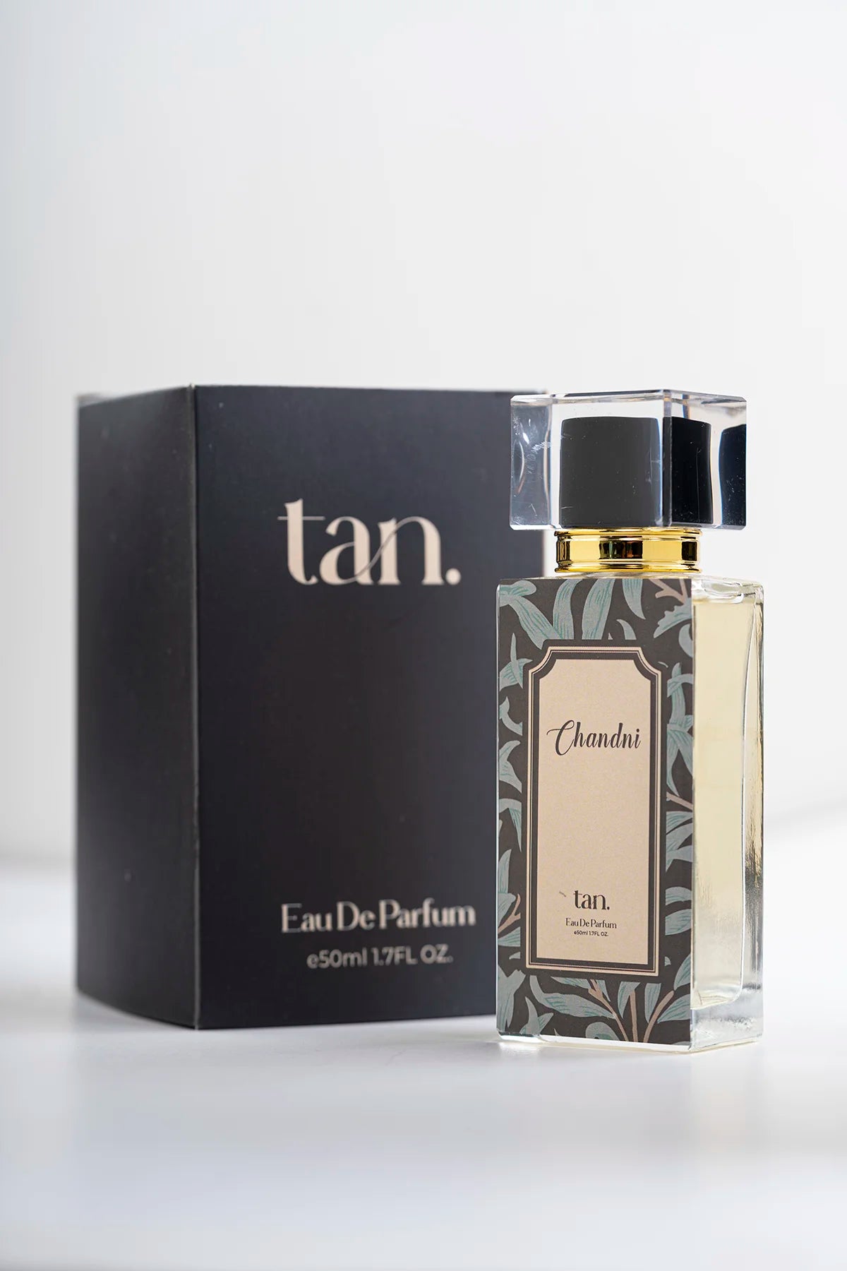 A 50ml (EDP) bottle of Chandni perfume for men and women with a black gift box by tan.